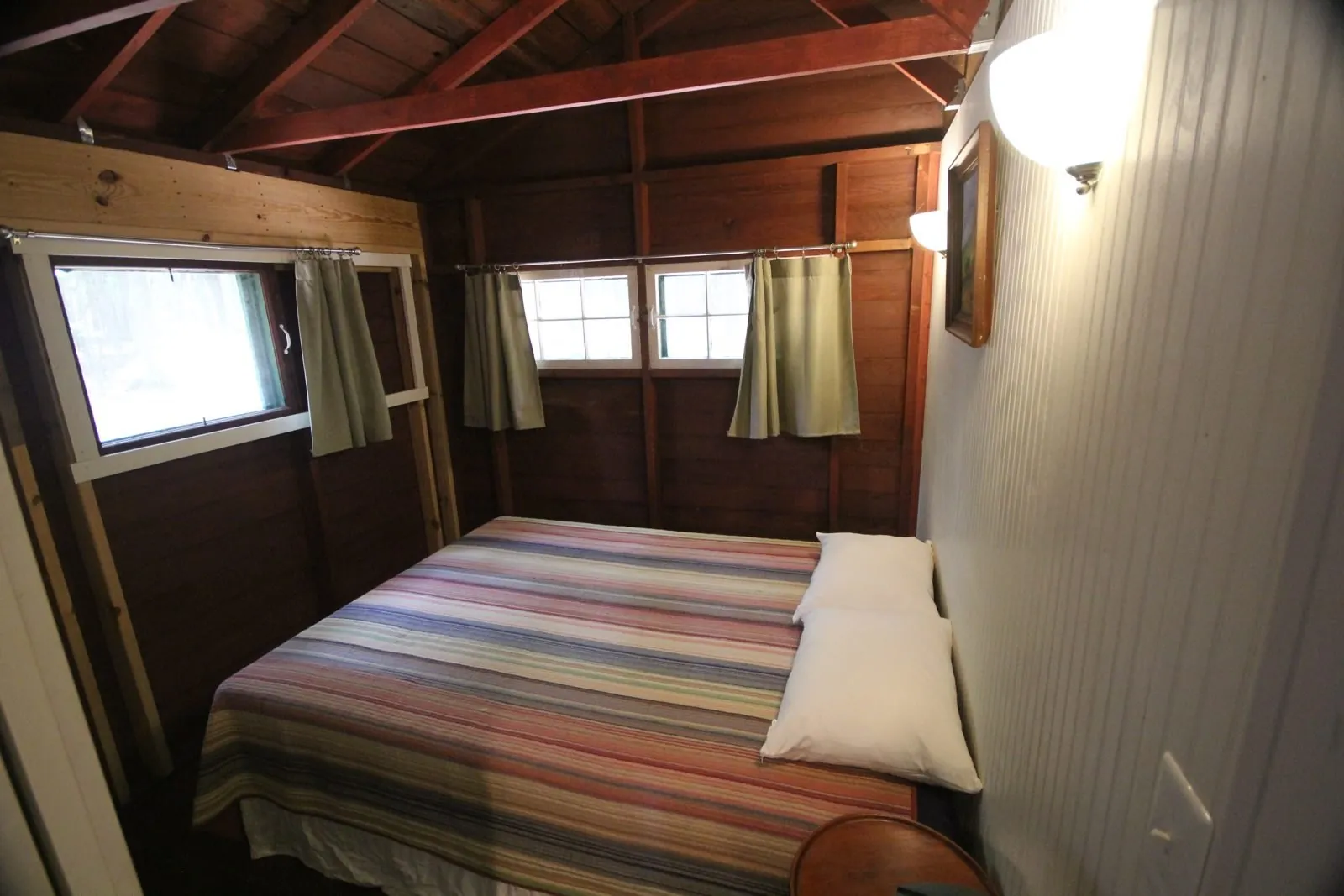 Bedroom in Davis Cottage with a queen bed and striped quilt