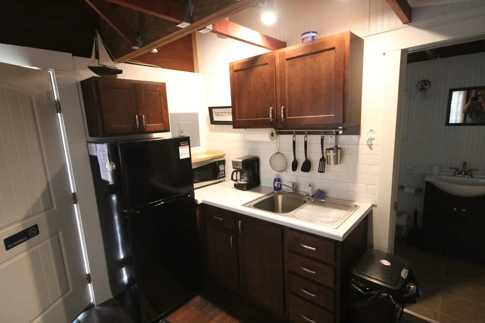 Davis Cottage kitchen with dark wood cabinets and full-size refrigerator
