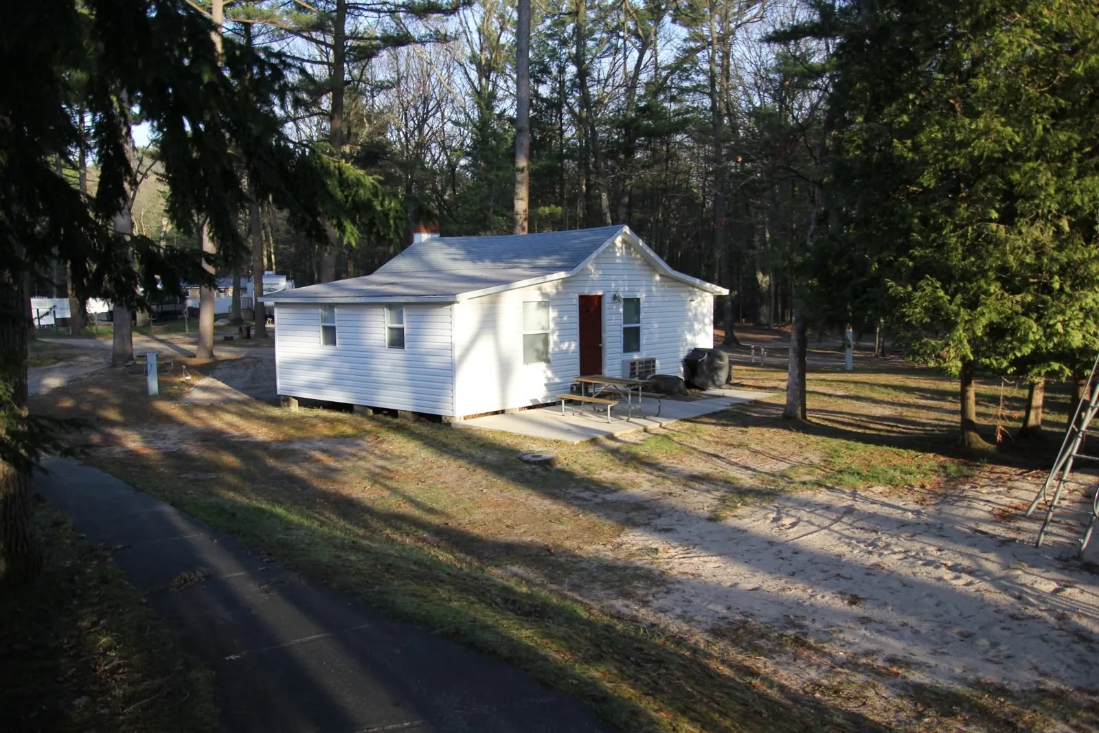 Dorothy Cottage seen from the campground road among tall trees