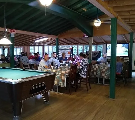 Campers dining in the Lodge next to the pool table
