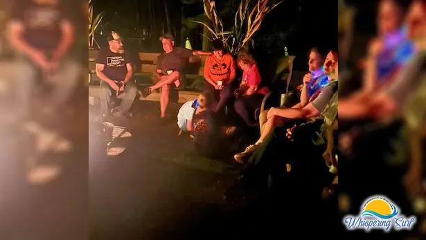 Campers in costumes around the community fire on Halloween night
