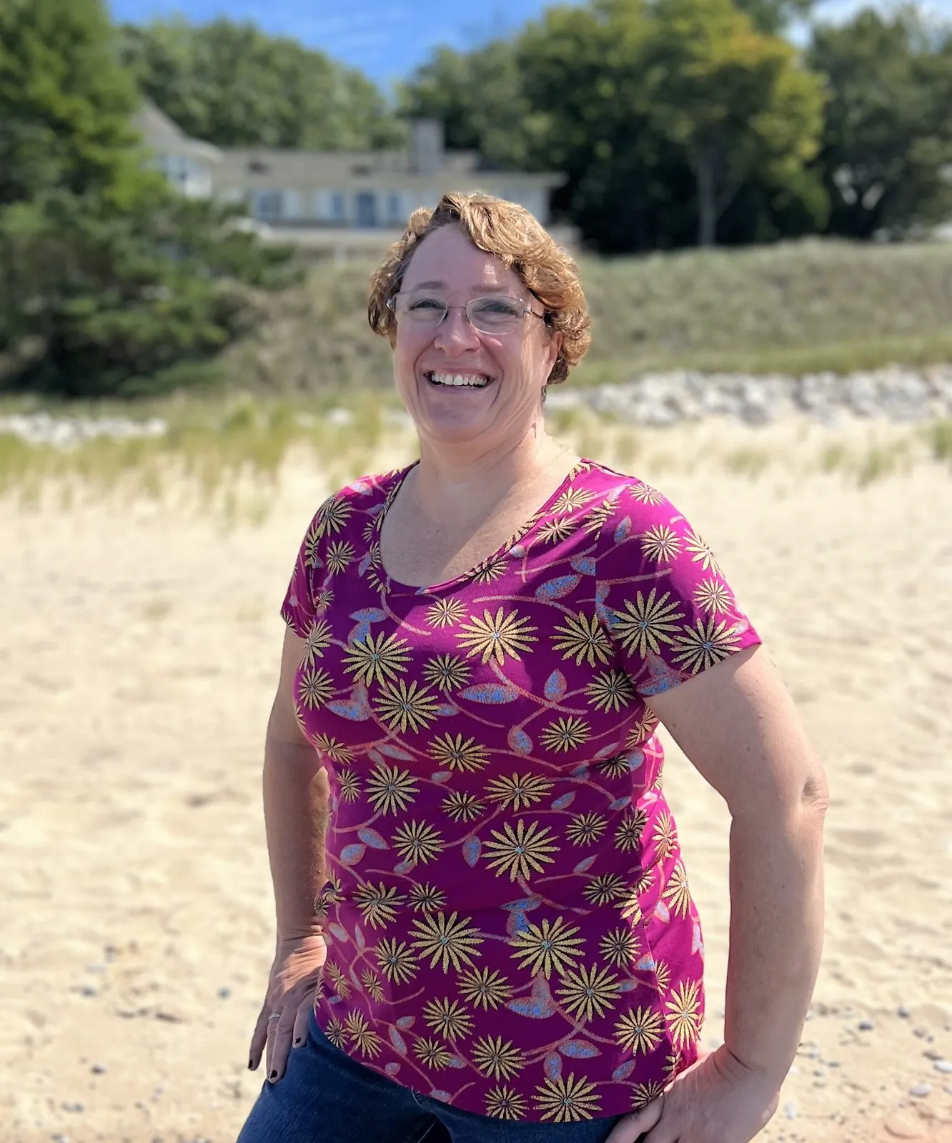 Lisa, owner of Whispering Surf, standing on a sandy Lake Michigan dune